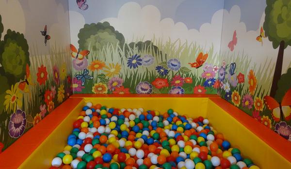 Softplay ruimte met ballenbad en wanddecoratie